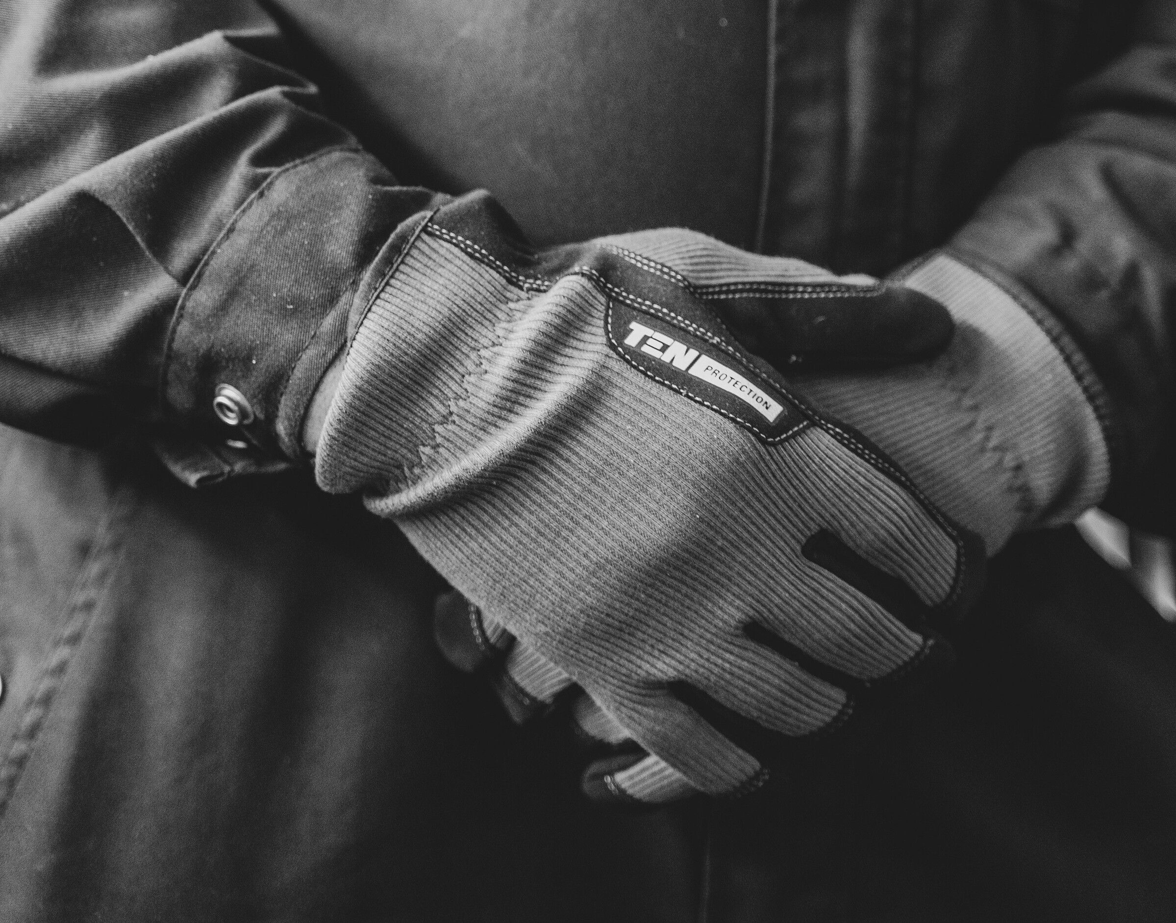 Hände mit Arbeitshandschuhen aus robustem Material